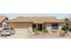 Charming single-story home with desert landscaping, a tile roof and attached two-car garage at 9814 W Menadota Dr, Peoria, AZ 85382