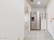 Hallway view showcases stainless steel refrigerator and tile floors at 9814 W Menadota Dr, Peoria, AZ 85382