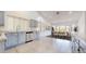 Bright kitchen with gray cabinets, tile floors, and view into the dining room at 9814 W Menadota Dr, Peoria, AZ 85382