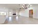 Open-concept living room with fireplace, ceiling fan, chandelier, and access to the kitchen area at 9814 W Menadota Dr, Peoria, AZ 85382