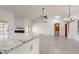 Bright living area with a fireplace, ceiling fan, tile floors, and an adjacent dining area at 9814 W Menadota Dr, Peoria, AZ 85382