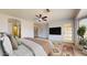 Spacious main bedroom with ceiling fan, large window, and television at 9814 W Menadota Dr, Peoria, AZ 85382