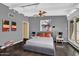 Well-lit bedroom with a large window, wooden floor, stylish decor, and a gray accent wall at 1029 E Palo Verde Dr, Phoenix, AZ 85014