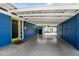 Spacious carport featuring block wall, yellow door, and a well-maintained concrete floor at 1029 E Palo Verde Dr, Phoenix, AZ 85014