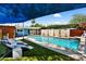 A resort-style pool is surrounded by lush grass, lounge chairs, and privacy landscaping at 1029 E Palo Verde Dr, Phoenix, AZ 85014