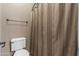 Bathroom with toilet, towel bar, and shower with beige curtain at 1101 W Oleander Ave, Queen Creek, AZ 85140