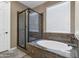 Bathroom featuring a glass-enclosed shower and a white tub beneath a window at 1101 W Oleander Ave, Queen Creek, AZ 85140