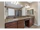 Bathroom with double vanity, granite countertops, and a large mirror reflecting a glass-enclosed shower at 1101 W Oleander Ave, Queen Creek, AZ 85140