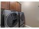 Laundry room features new Whirlpool washer and dryer with dark cabinets at 1101 W Oleander Ave, Queen Creek, AZ 85140