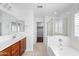 Bathroom featuring tile floors, cherry-wood cabinets, a walk-in shower, and a soaking tub at 12546 N 142Nd Ln, Surprise, AZ 85379