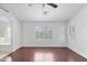 Bright bedroom featuring hardwood floors, a ceiling fan, and white plantation shutters at 12546 N 142Nd Ln, Surprise, AZ 85379