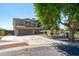 Stunning exterior view of a two-story home with a spacious driveway and lush landscaping, complemented by mature shade trees at 12546 N 142Nd Ln, Surprise, AZ 85379