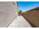 Long side yard with a concrete walkway, a privacy wall, and a wooden gate at 12546 N 142Nd Ln, Surprise, AZ 85379