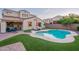Beautiful backyard featuring a sparkling pool, lounge chairs, well-manicured lawn, and covered patio at 13318 W Indianola Ave, Litchfield Park, AZ 85340
