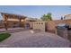 Inviting outdoor space with covered pergola, seating, built-in grill, and fire feature for entertaining at 13318 W Indianola Ave, Litchfield Park, AZ 85340