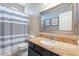 Bathroom featuring granite countertops, a framed mirror and a shower with a striped curtain at 13318 W Indianola Ave, Litchfield Park, AZ 85340