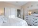 Bright bedroom featuring a double bed with white bedding, closet, and a dresser with decorative mirror at 13318 W Indianola Ave, Litchfield Park, AZ 85340
