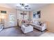 Cozy living room features an L-shaped couch with an ottoman, ceiling fan, and access to backyard at 13318 W Indianola Ave, Litchfield Park, AZ 85340
