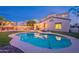Backyard with a kidney-shaped pool, manicured lawn, and patio furniture with comfortable lounge chairs at 13318 W Indianola Ave, Litchfield Park, AZ 85340