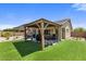 Lush backyard featuring a covered patio, well-maintained green lawn, and a private outdoor space at 1415 N Frederick Ln, Casa Grande, AZ 85122