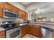 Bright kitchen features stainless appliances, wood cabinetry and a view through to the living area at 1415 N Frederick Ln, Casa Grande, AZ 85122