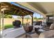Covered patio with outdoor seating, grill, hot tub, and view of the landscaped backyard at 1415 N Frederick Ln, Casa Grande, AZ 85122
