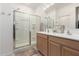 Bright bathroom with a glass-enclosed shower, double vanity, and a large mirror at 14233 W Georgia Dr, Surprise, AZ 85379