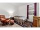 Cozy bedroom with a patterned bedspread, a leather recliner and ottoman, and a classic wood dresser at 14233 W Georgia Dr, Surprise, AZ 85379