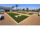 Community bocce ball court surrounded by gravel and benches, featuring a well-maintained lawn at 14233 W Georgia Dr, Surprise, AZ 85379