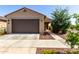 Charming single-level home showcasing a neutral-toned exterior with desert landscaping and a two-car garage at 14233 W Georgia Dr, Surprise, AZ 85379