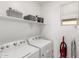 Convenient laundry room with washer, dryer, storage shelf, and natural light at 14233 W Georgia Dr, Surprise, AZ 85379