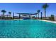 Community pool featuring sunshades, shallow entry, mature landscaping, and clear blue water at 14233 W Georgia Dr, Surprise, AZ 85379