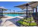 Poolside lounge area with modern seating and shade structures, with the pool in the background at 14233 W Georgia Dr, Surprise, AZ 85379
