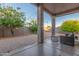 Inviting covered back patio with comfortable seating, set amidst lush landscaping and vibrant fruit trees at 14821 N 62Nd Ave, Glendale, AZ 85306