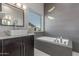 This primary bathroom is equipped with a granite vanity, a vessel sink, and a soaking tub with a flower accent at 14821 N 62Nd Ave, Glendale, AZ 85306