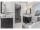 This primary bathroom is equipped with dual vessel sinks, granite vanities, lighting, and a soaking tub at 14821 N 62Nd Ave, Glendale, AZ 85306