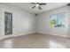 This bedroom features neutral walls, hardwood floors, a ceiling fan, a door to the exterior, and a large window at 14821 N 62Nd Ave, Glendale, AZ 85306