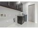 Well-lit laundry room with ample overhead storage, a utility sink, and a convenient water softener system at 14821 N 62Nd Ave, Glendale, AZ 85306