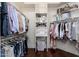 Spacious walk-in closet with custom shelving, hanging rods, and hardwood flooring for organized storage at 15240 N Clubgate Dr # 160, Scottsdale, AZ 85254