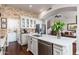 Bright kitchen features white cabinets, stainless steel appliances, a brick wall, and a large island at 15240 N Clubgate Dr # 160, Scottsdale, AZ 85254