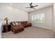 Comfortable living room with plush brown sofa, plantation shutters, and neutral carpet at 15240 N Clubgate Dr # 160, Scottsdale, AZ 85254