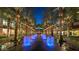 Beautifully illuminated street view with palm trees and decorative fountains at dusk at 15240 N Clubgate Dr # 160, Scottsdale, AZ 85254