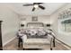 Bright bedroom featuring a wrought iron bed frame, ceiling fan and neutral colored walls at 16219 W Yucatan Dr, Surprise, AZ 85379