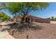 Exterior view of a tan single-story home with a two-car garage and desert landscaping at 16219 W Yucatan Dr, Surprise, AZ 85379