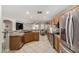 Well-lit kitchen with granite countertops, stainless steel appliances, tile floors, and open access to the living area at 16219 W Yucatan Dr, Surprise, AZ 85379