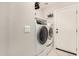Functional laundry area with modern, front-loading washer and dryer units, tile flooring, and access to the exterior at 16219 W Yucatan Dr, Surprise, AZ 85379