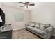 A well-lit living room showing a sofa and throw pillows, carpet, and ceiling fan at 16219 W Yucatan Dr, Surprise, AZ 85379
