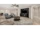 Spacious living room featuring tile floors, a ceiling fan, comfortable seating, and a large entertainment center at 16219 W Yucatan Dr, Surprise, AZ 85379