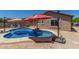 Sparkling pool with red umbrellas and outdoor seating offers a relaxing retreat in a private backyard at 16219 W Yucatan Dr, Surprise, AZ 85379