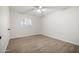 A bright, empty bedroom shows hardwood floors, a ceiling fan, and a window at 1628 E Sunland Ave, Phoenix, AZ 85040